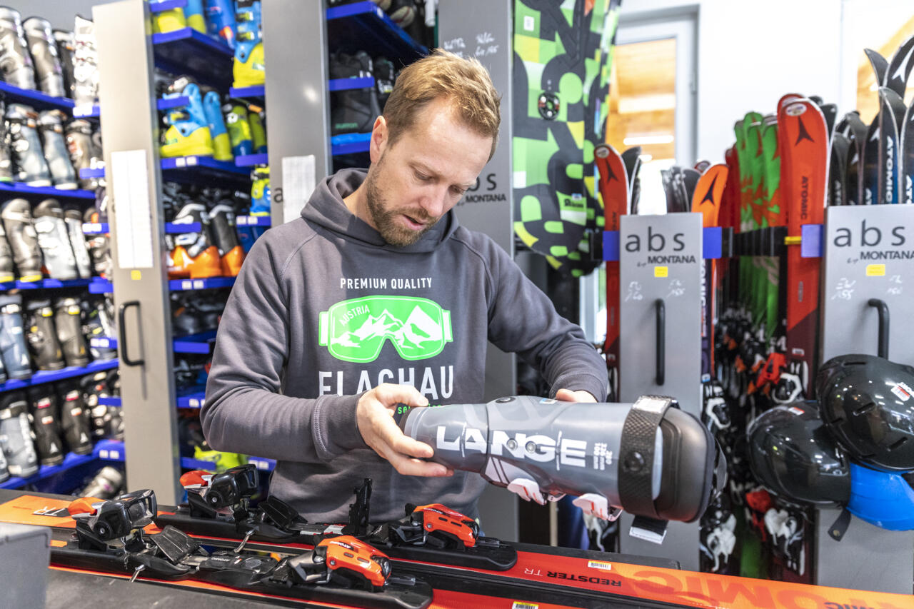 Ein Mitarbeiter prüft einen grauen Skischuh